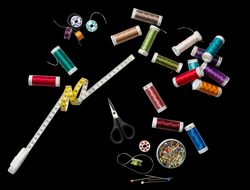 Sewing threads, measuring tape, scissors, pins, and accessories arranged neatly